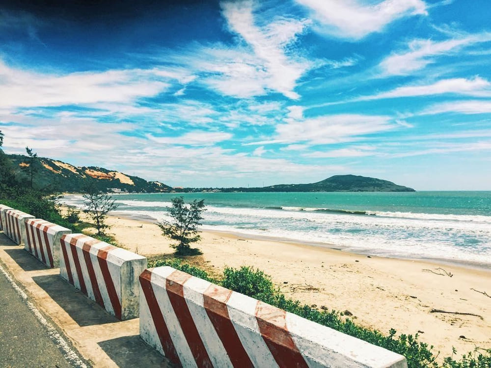 Hon Rom Beach's pristine white sand stretching beneath the mountain with crystal-clear waters perfect for family swimming